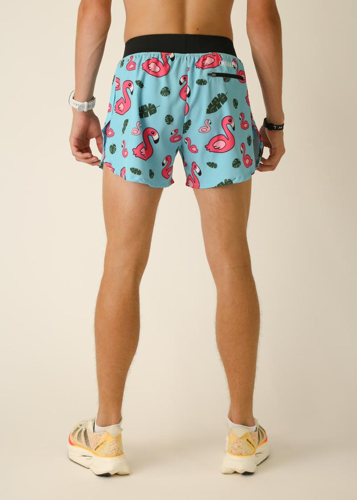 Model wearing Chicknlegs in men's 4 inch split running shorts in the blue flamingo design, facing back.