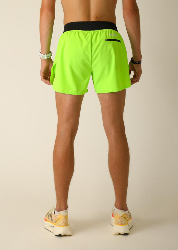 Model wearing Chicknlegs men's 4 inch split running shorts in the neon green design, facing back
