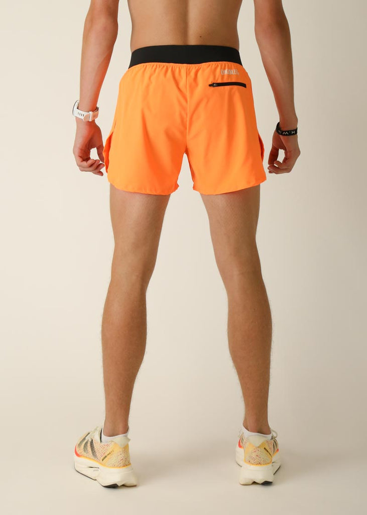 Model wearing Chicknlegs men's 4 inch split running shorts in the neon orange design, facing back for back view.