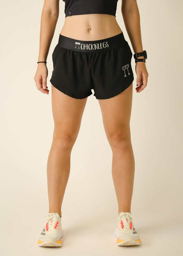 Model wearing Chicknlegs women's 1.5 inch split running shorts in the black design, facing front.