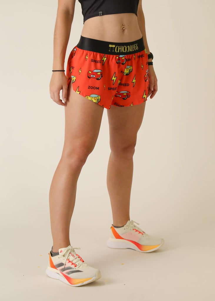 Model wearing Chicknlegs women's 1.5 inch split running shorts in the cars design facing right for right side view.