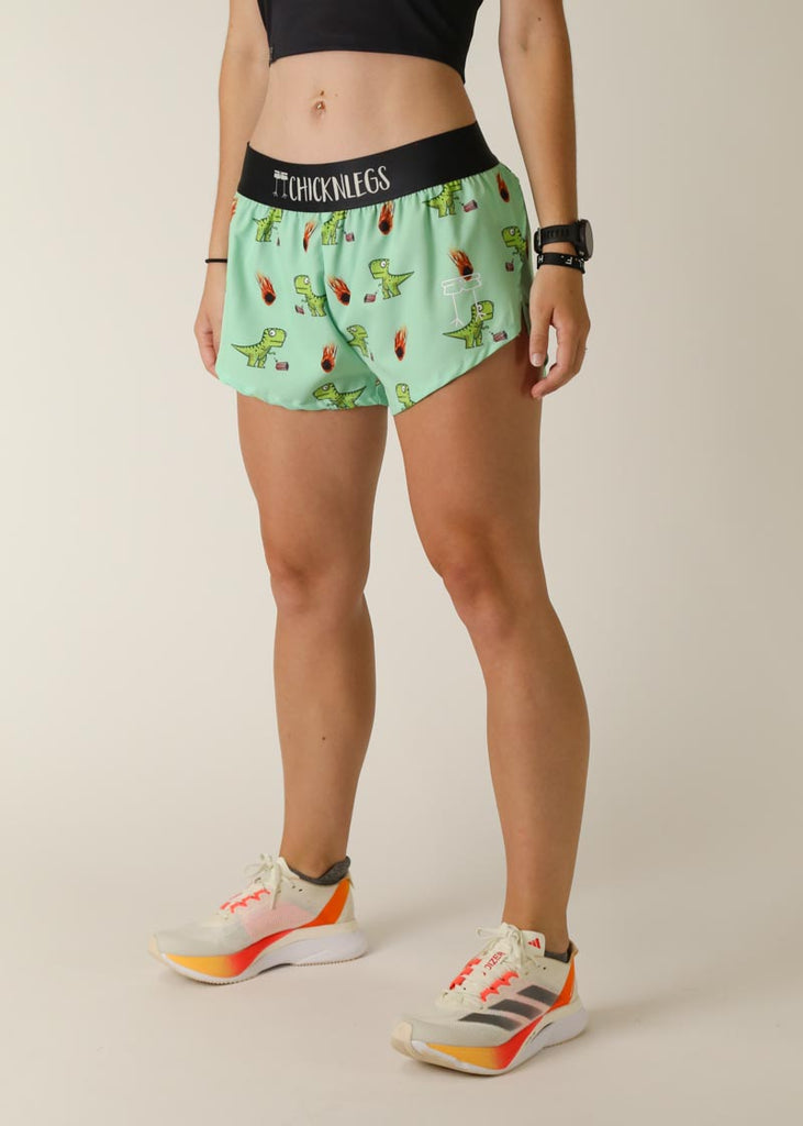 Model wearing Chicknlegs women's 1.5 inch split running shorts in the dino's - dino-sore design facing left for left side view.