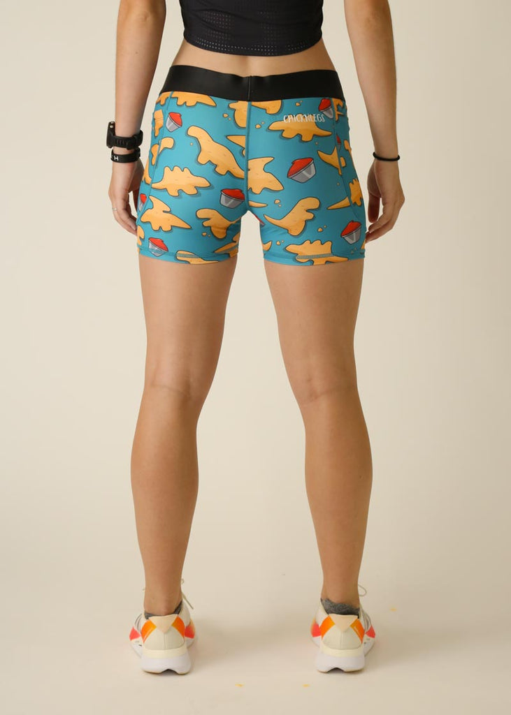 Model is wearing Chicknlegs women's 3 inch compression shorts for running in the dino-nuggets design, facing the back.