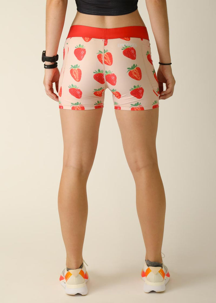 Model is wearing Chicknlegs women's 3 inch compression shorts for running in the strawberry szn design, facing back.