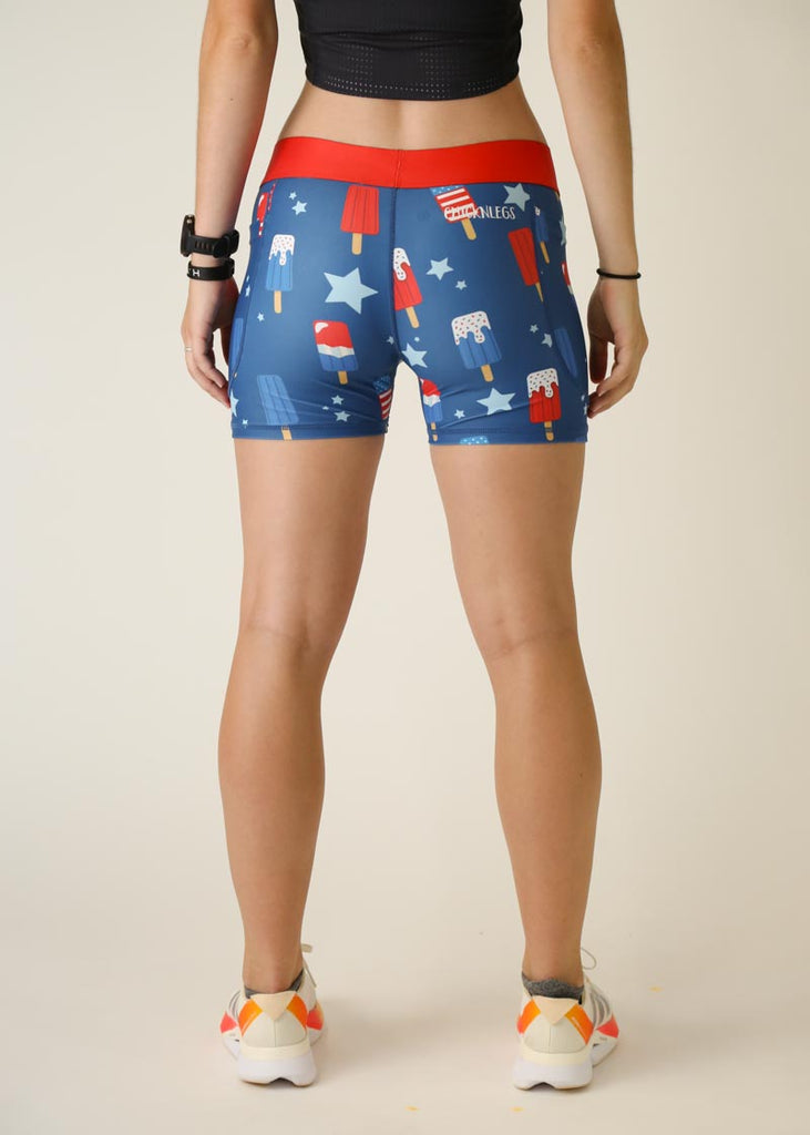 Model is wearing Chicknlegs women's 3 inch compression shorts for running in the usa popsicles design, facing the back.