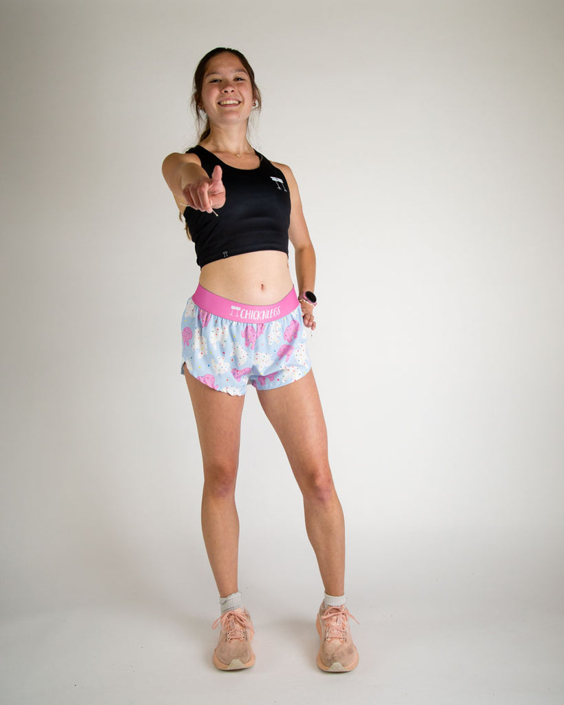 Runner is wearing ChicknLegs in the women's 1.5 in split running shorts in the animal cookies design. The print has white, pink and blue on it. A ton of fun frosted covered animal cookies with rainbow sprinkles. 
