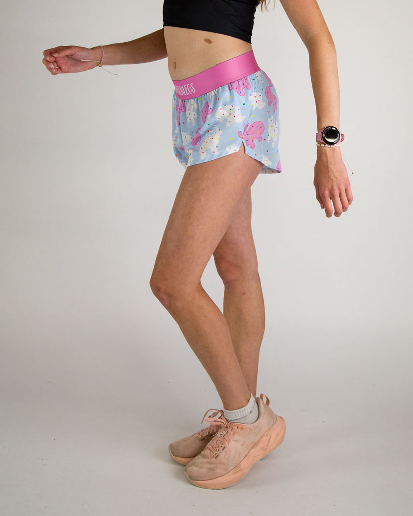Runner is wearing ChicknLegs in the women's 1.5 in split running shorts in the animal cookies design. The print has white, pink and blue on it. A ton of fun frosted covered animal cookies with rainbow sprinkles. Shorts have soft material to help with chaffing.