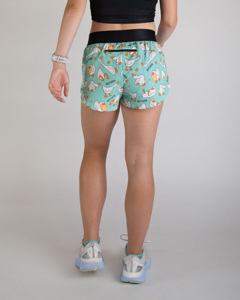 Runner is wearing ChicknLegs in the women's 1.5 split running shorts in the silly goose design. The print has yellow, white, orange, and blue on it. The zipper has a back pocket on it thats great for snacks, phones, airpods, and runners gear!