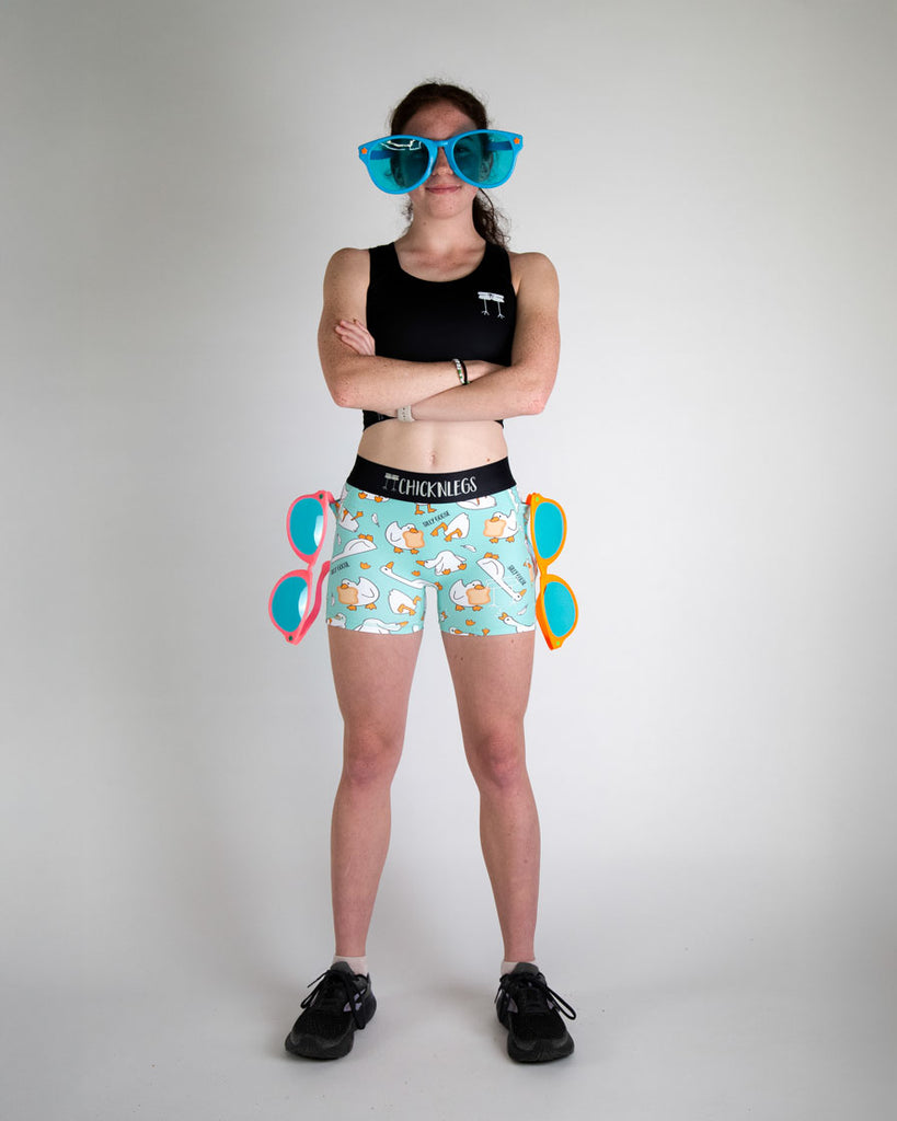 Runner is wearing ChicknLegs in the women's 3 in compression spandex shorts in the silly goose design. A full body image is shown of the model wearing the compression with a pwr crop top from ChicknLegs.