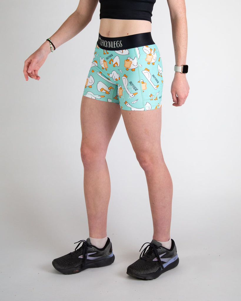Runner is wearing ChicknLegs in the women's 3 in compression spandex shorts in the silly goose design. The print has yellow, white, orange, and blue on it. Funny print for those who love animals and bread.