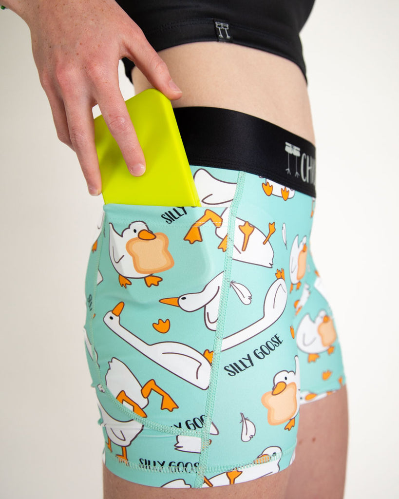 A close up image is shown of the model putting a phone into the side pocket of the compression spandex shorts.