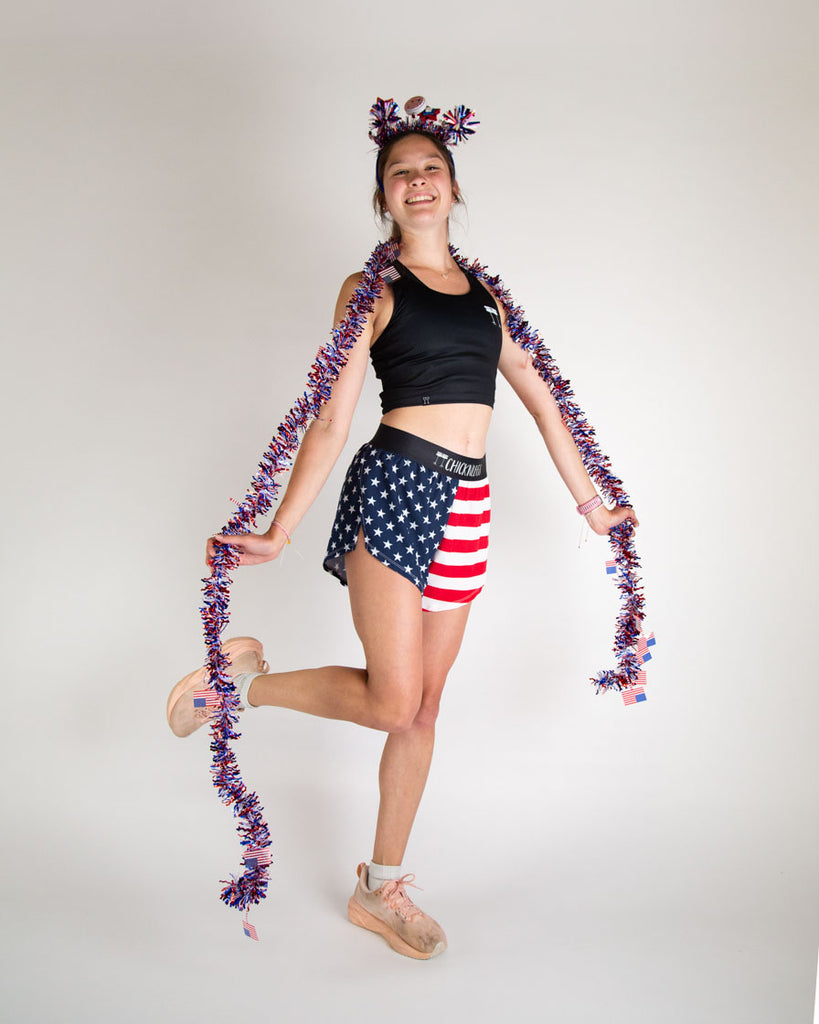 Runner is wearing ChicknLegs in the women's 4 in split running shorts in the USA state flag print that is red, white and blue. Great for people who love 4th of july.