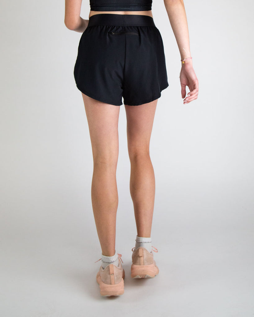 Runner is wearing ChicknLegs in the women's 4 in split running shorts in the solid black design. The print is great for matching sleek fits that go great with other prints or products.