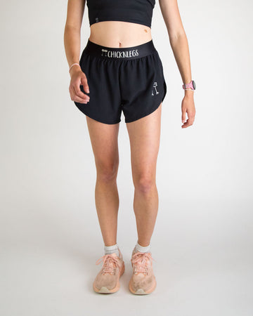 Runner is wearing ChicknLegs in the women's 4 in split running shorts in the solid black design. The print is great for matching sleek fits that go great with other prints or products.
