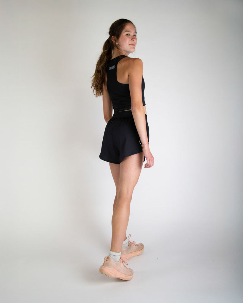 Runner is wearing ChicknLegs in the women's 4 in split running shorts in the solid black design. The print is great for matching sleek fits that go great with other prints or products.