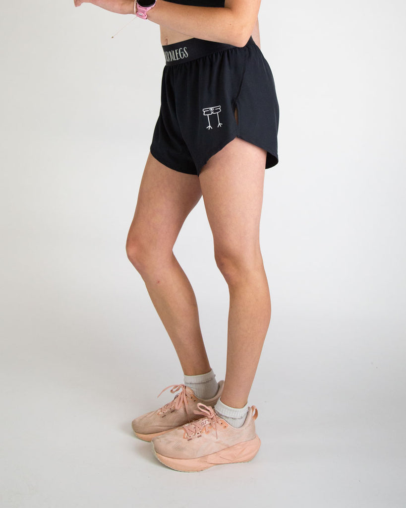 Runner is wearing ChicknLegs in the women's 4 in split running shorts in the solid black design. The print is great for matching sleek fits that go great with other prints or products.