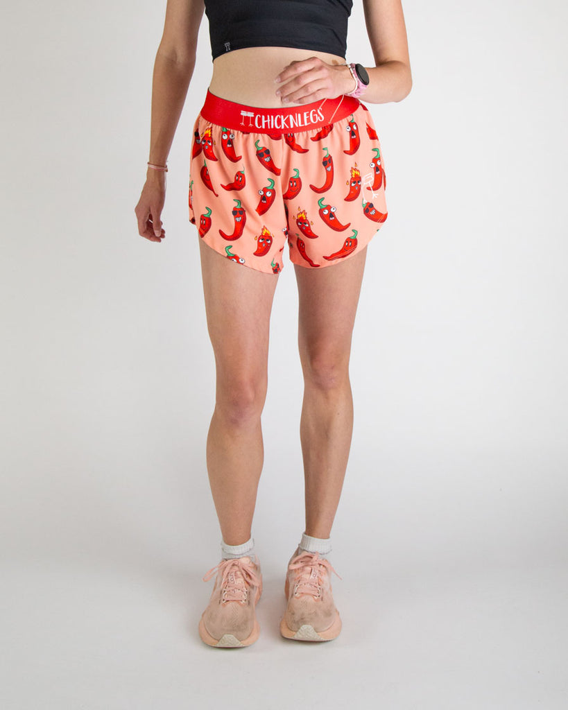 Runner is wearing ChicknLegs in the women's 4 in split running shorts in the chili pepper design. The print has fun red, green and orange all over it for people who love spicy. Great for food lovers and funny designs.
