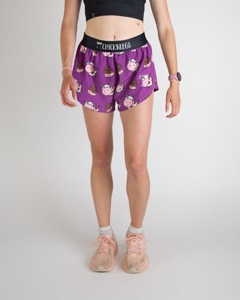 Runner is wearing ChicknLegs in the women's 4 in split running shorts in the choccy cow design. The print has brown cows on it with chocolate milk.