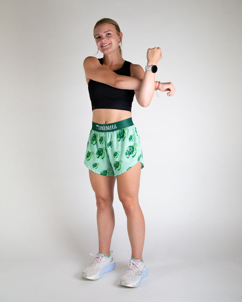 Runner is wearing ChicknLegs in the women's 4 in split running shorts. The print has sea turtles on it that are green with bubbles. 