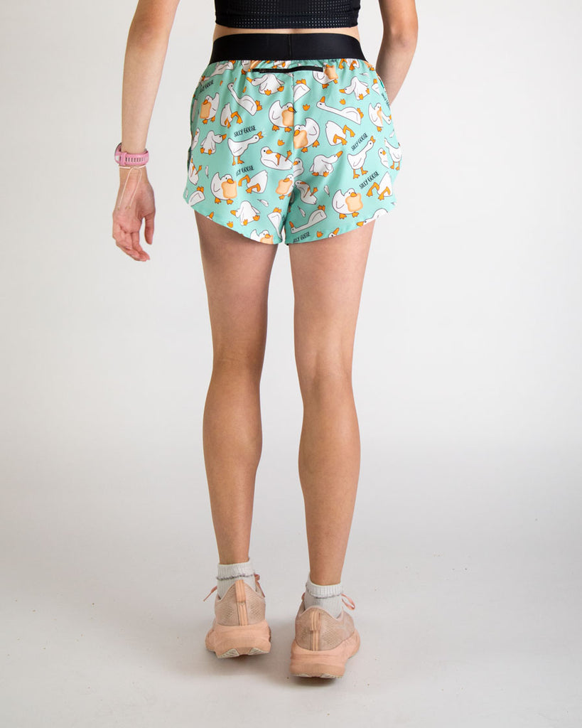 Runner is wearing ChicknLegs in the women's 4 in split running shorts in the silly goose design. The print has white, orange and blue on it with a bunch of geese. The back of the shorts have a zipper pocket that can help carry airpods, phones, snacks and other runners gear!