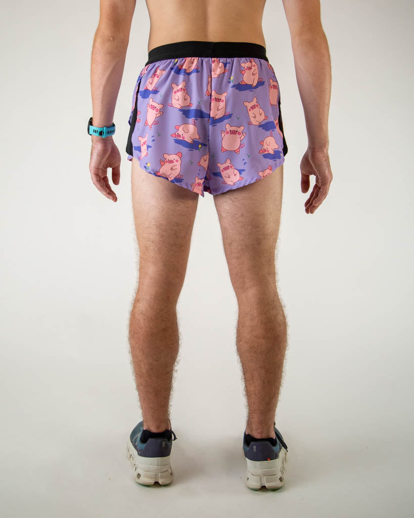 Back view of ChicknLegs men’s 2-inch split running shorts with drawstring, breathable liner, lilac purple background and pink piggies design.