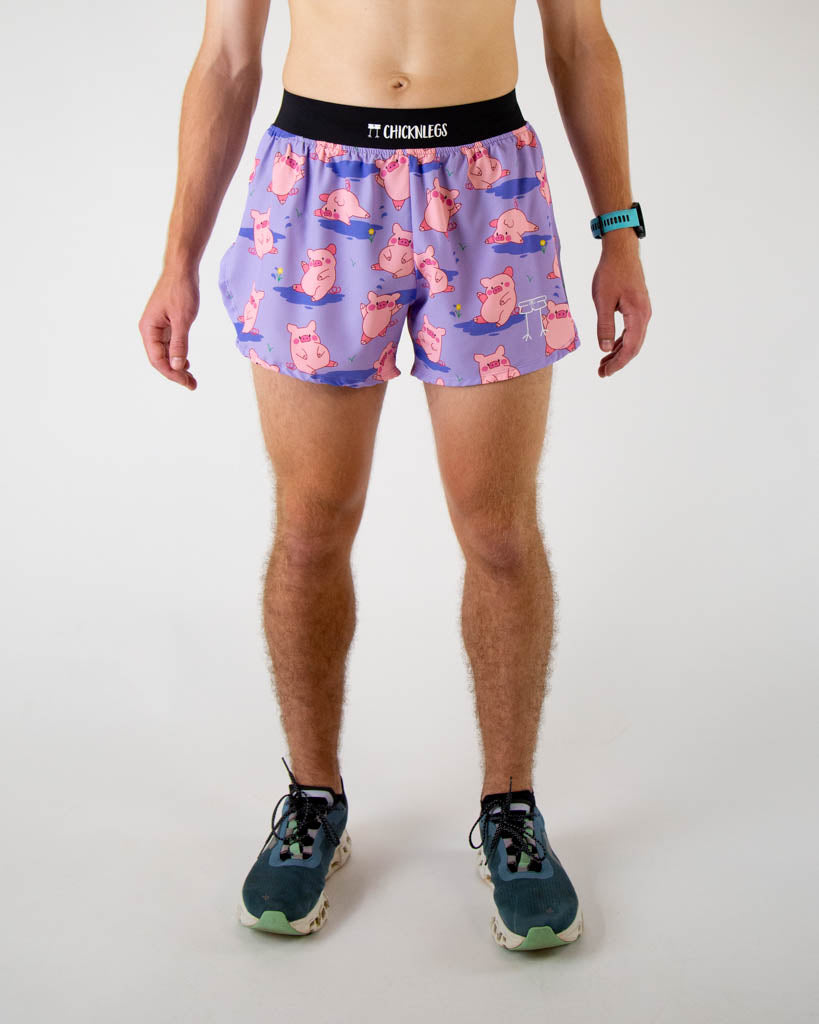 Front view of ChicknLegs men’s 4-inch split running shorts, breathable liner, lilac purple background and pink piggies on the design.