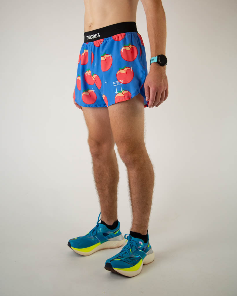 Left side view of ChicknLegs men’s 4-inch split running shorts with, breathable liner, blue background and juicy peaches on the design.