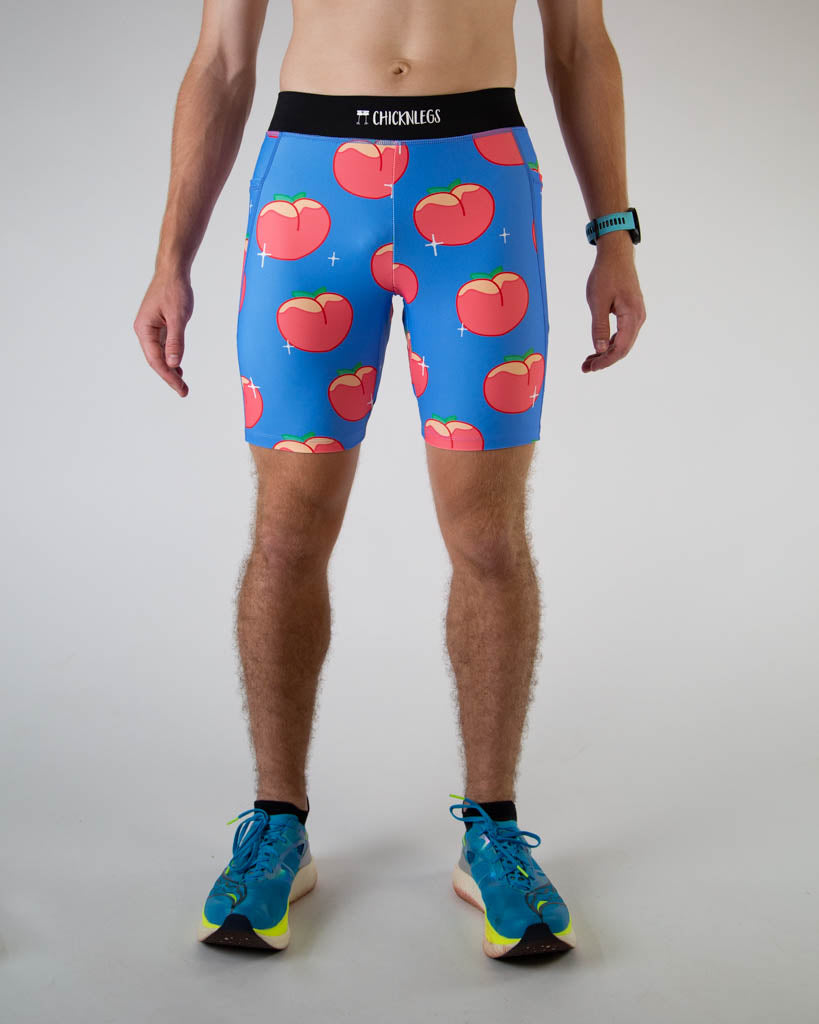 Front view of ChicknLegs men’s 8-inch half tights, breathable liner, blue background and juicy peaches design, paired with blue shoes.