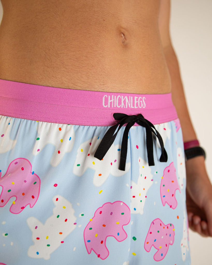 Runner is wearing ChicknLegs in the men's 2 in drawstrings split running shorts in the Animal Cookies design. A close up image is shown of the drawstrings.