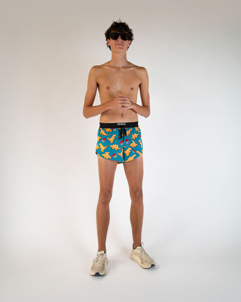 Runner is wearing ChicknLegs in the men's 2 in drawstrings in the split running shorts. The design has dinosaur  chicken nuggets on them with ketchup sauces. These shorts have blue, orange and red on them.