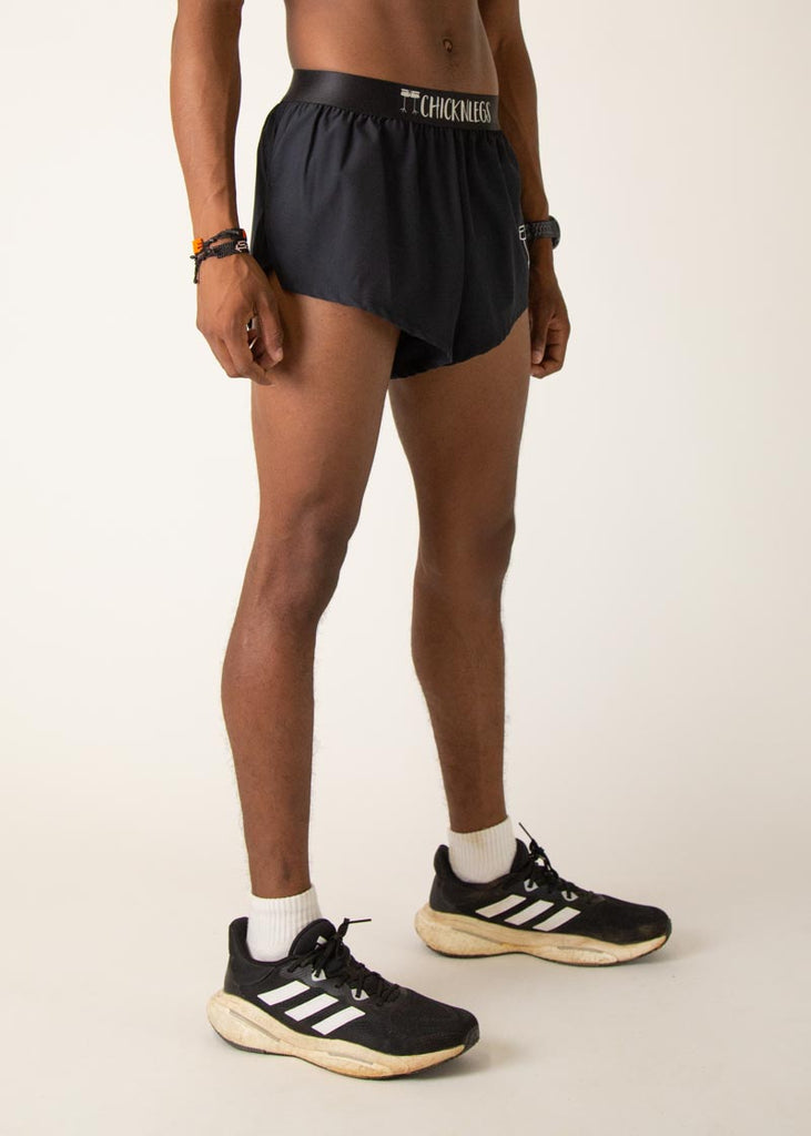 Model is wearing Chicknlegs in the mens 2 inch split running shorts in the black design, facing right