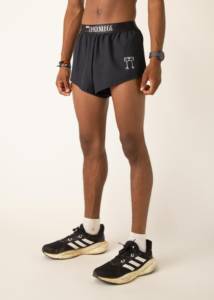 Model is wearing Chicknlegs in the mens 2 inch split running shorts in the black design, facing left