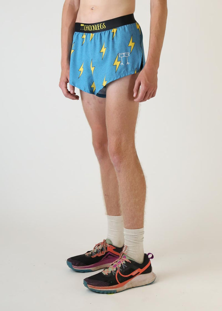 Model wearing chicknlegs mens 2 inch split running shorts with blue bolts design left side view