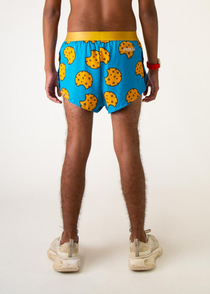 The model is a runner who is wering Chicknlegs in men's 2 inch split running shorts in the cookies design, facing away from the camera to show the back of the shorts.