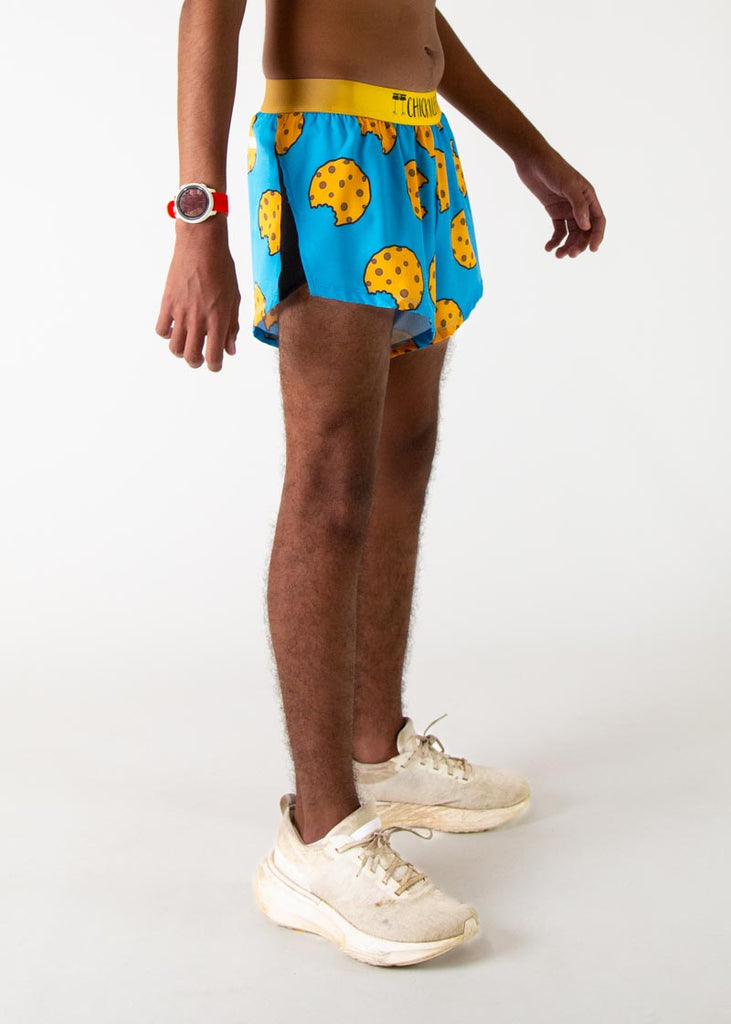 The model is a runner who is wering Chicknlegs in men's 2 inch split running shorts in the cookies design, facing right.