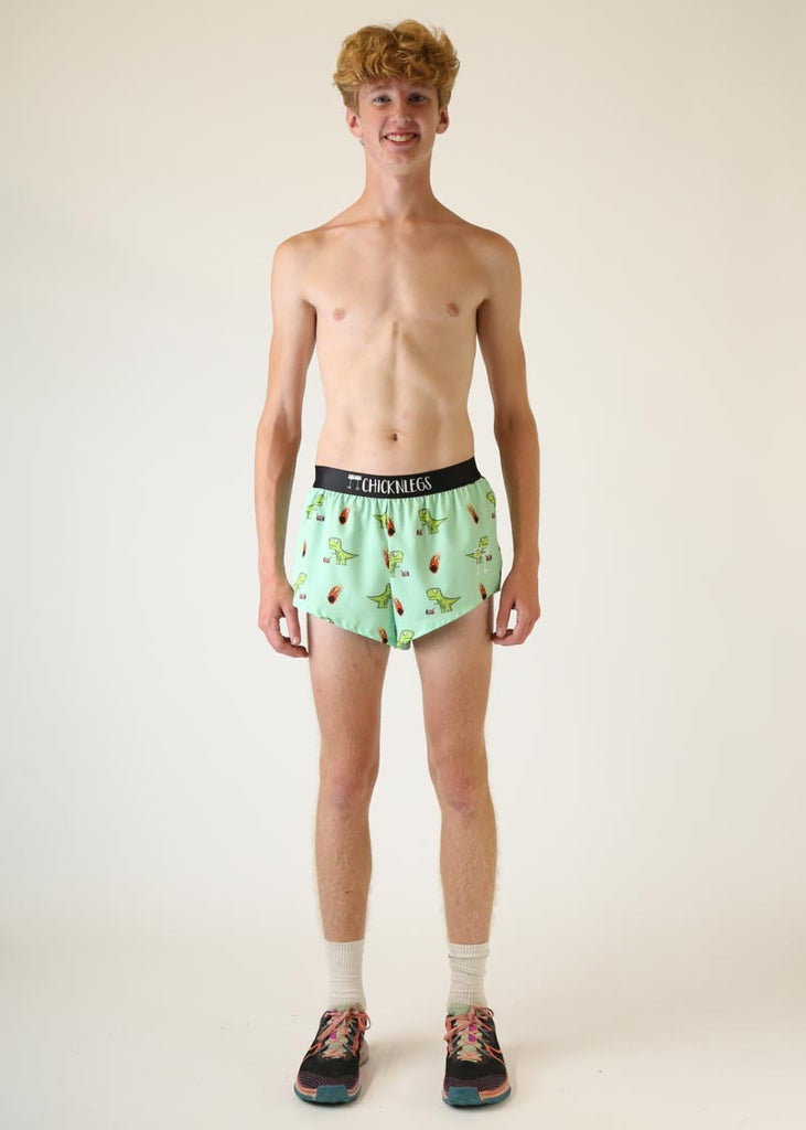 Model wearing Chicknlegs men's 2 inch split running shorts wearing dino design full body pose