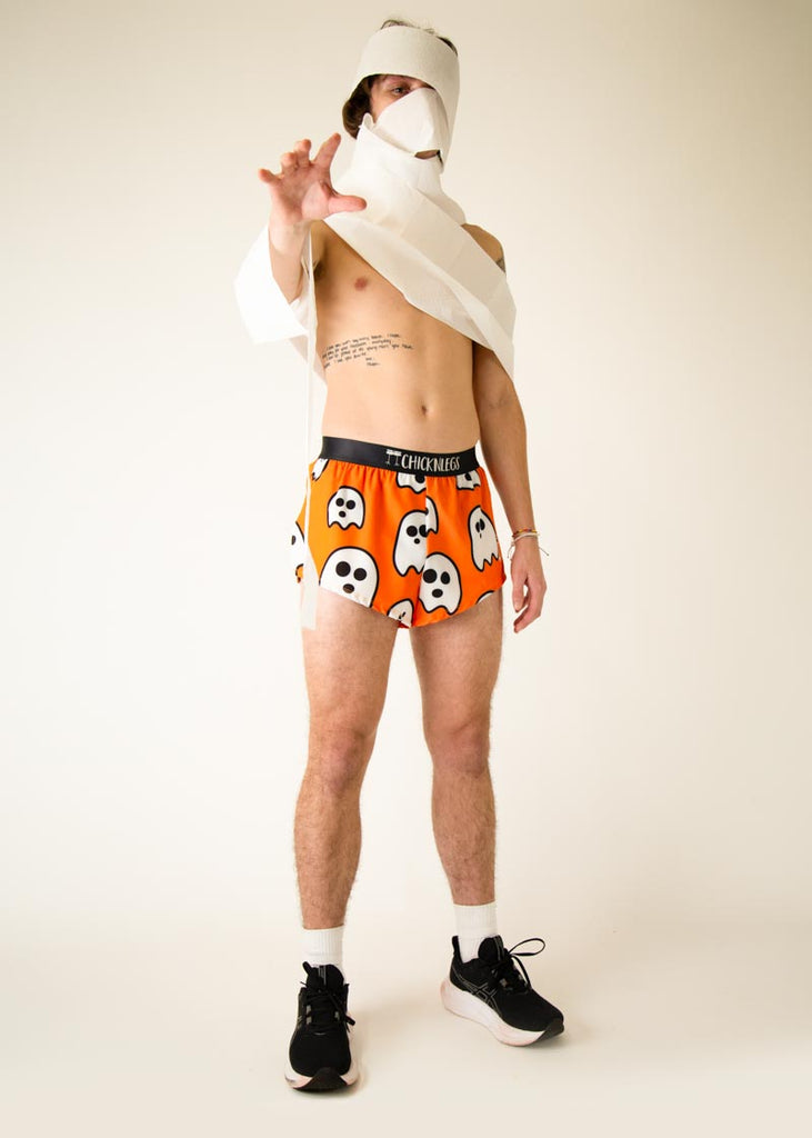Model is wearing Chicknlegs men's 2 inch split running shorts in the Ghost design, facing front while posing and wearing white paper around them.