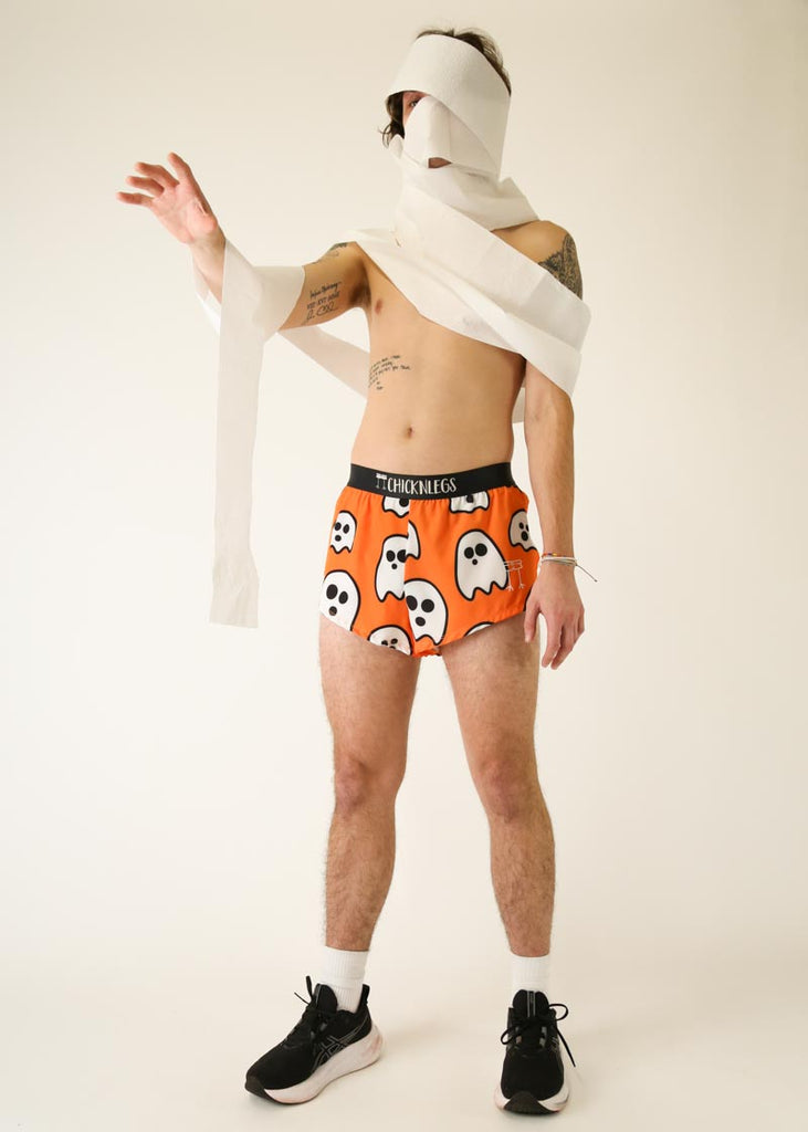 Model is wearing Chicknlegs men's 2 inch split running shorts in the Ghost design, facing front while posing and wearing white paper around them.
