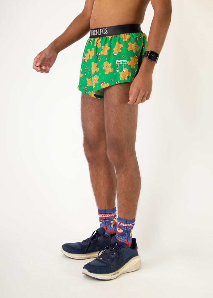 The model is a runner who is wearing Chicknlegs men's 2 inch split running shorts in the Gingerbread Men's Gingy Revenge design, facing left.