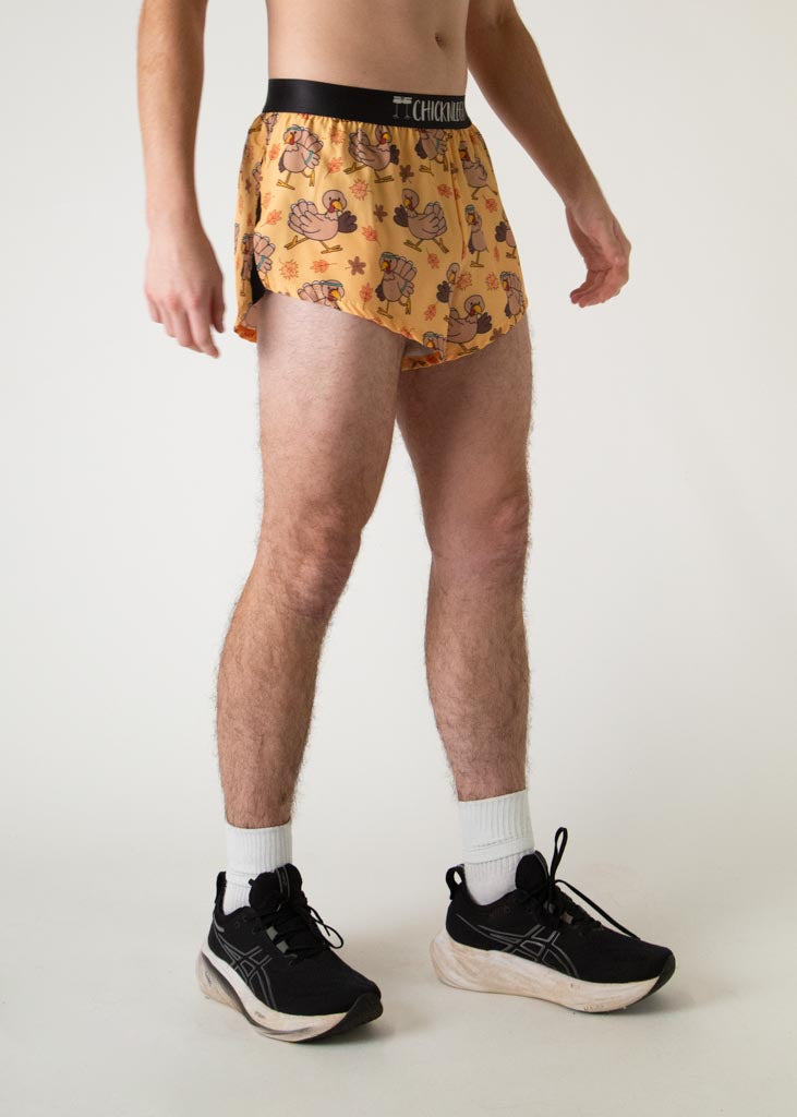 The model is a runner who is wearing Chicknlegs in men's 2 inch split running shorts in the pardoned turkey design, facing right.