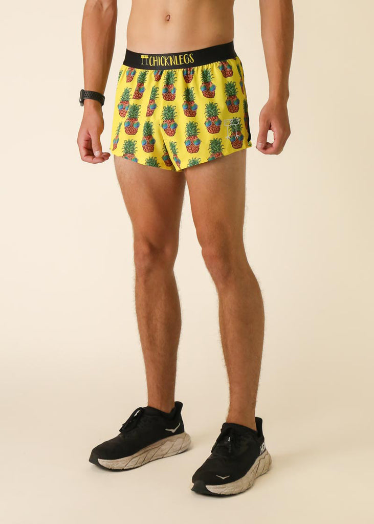 Runner is wearing ChicknLegs in the men's 2 in split running shorts with the pineapple express design. The print has sunglasses on pineapples on a yellow background.