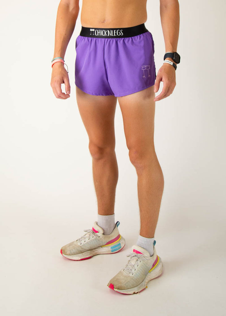 The model is a runner wearing Chicknlegs men's 2 inch split running shorts in the purple design, facing left.
