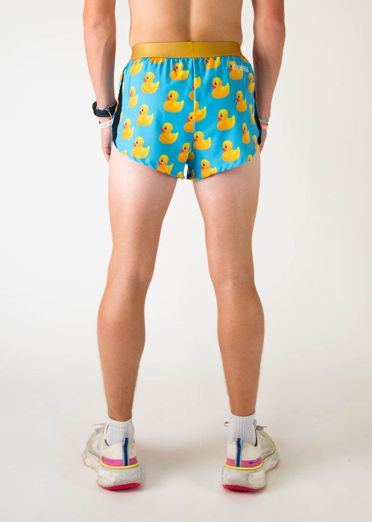 The model is a runner wearing Chicknleg's men's 2 inch split running shorts in the rubber ducky design, facing away from the camera to show the shorts.
