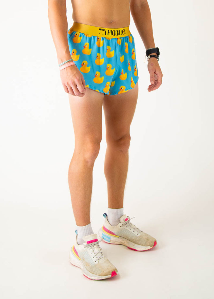 The model is a runner wearing Chicknleg's men's 2 inch split running shorts in the rubber ducky design, facing right.
