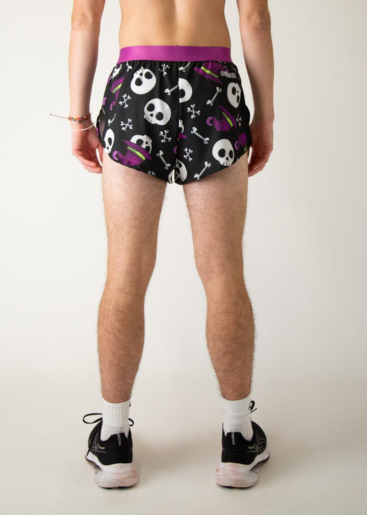 Model is a runner wearing Chicknlegs men's 2 inch split running shorts in the Skulls design, facing away from the camera to show the back view.