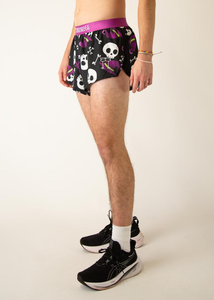 Model is a runner wearing Chicknlegs men's 2 inch split running shorts in the Skulls design, facing left.