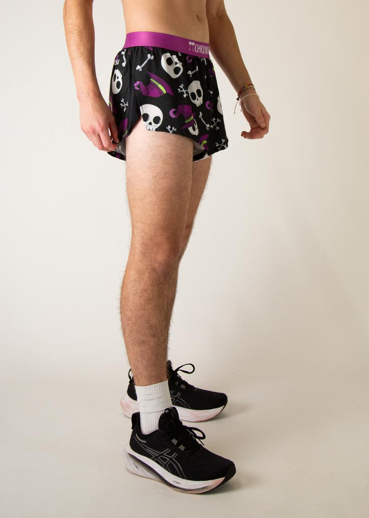 Model is a runner wearing Chicknlegs men's 2 inch split running shorts in the Skulls design, facing right.