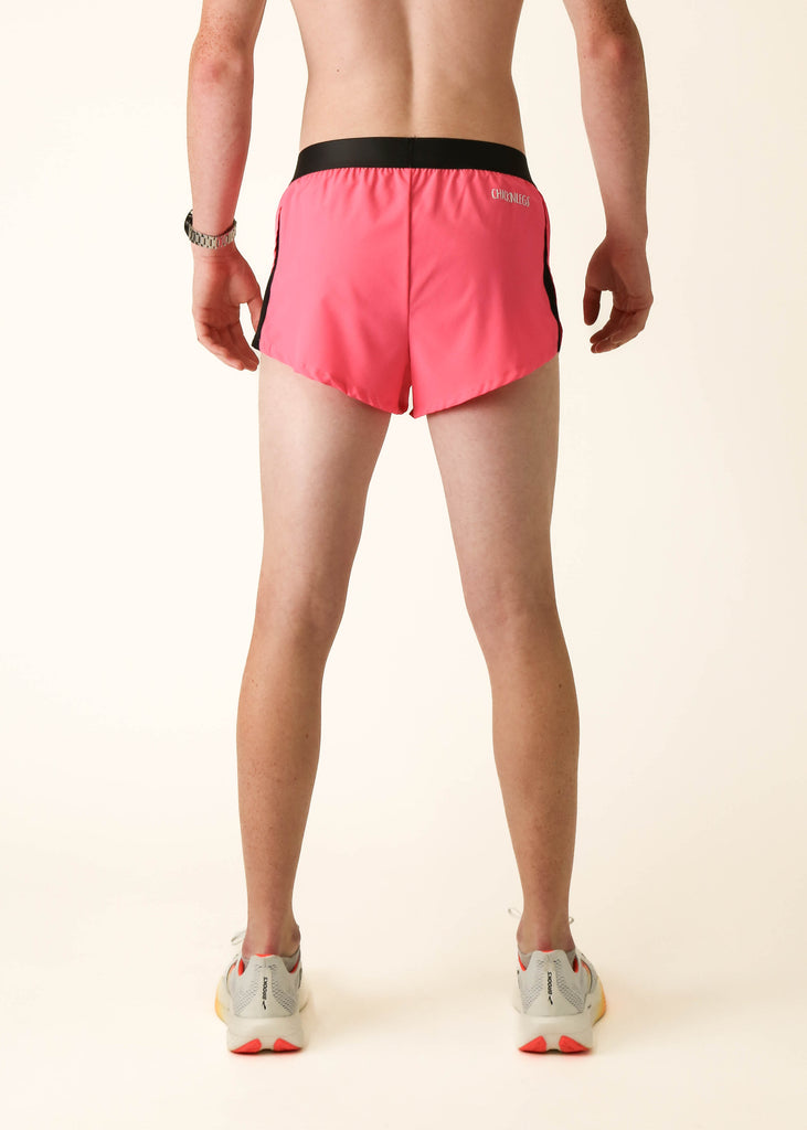 Model wearing Chicknlegs men's 2 inch split running shorts in the neon pink design facing back for back view.
