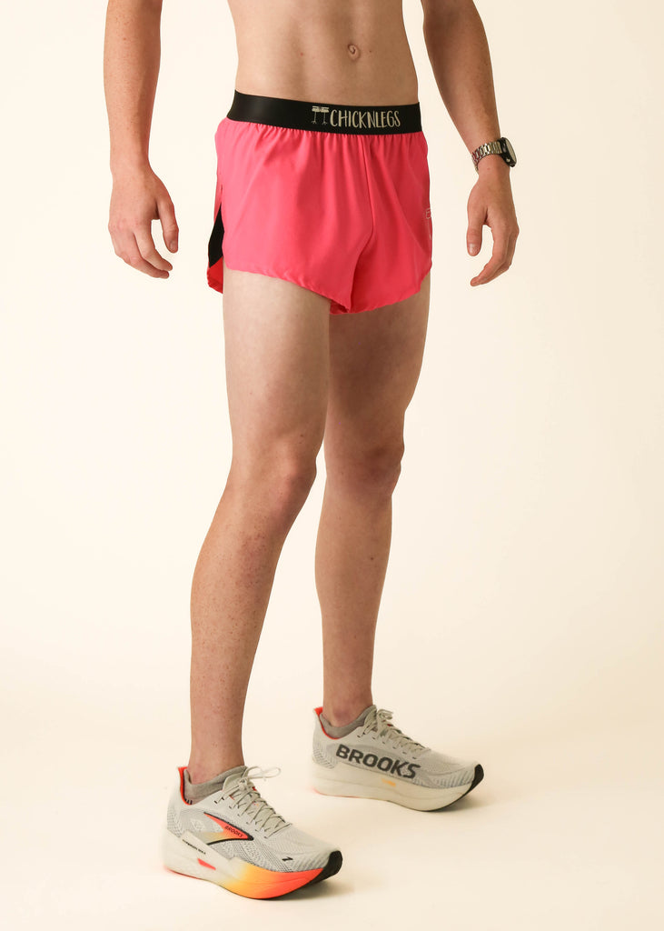 Model wearing Chicknlegs men's 2 inch split running shorts in the neon pink design facing left.
