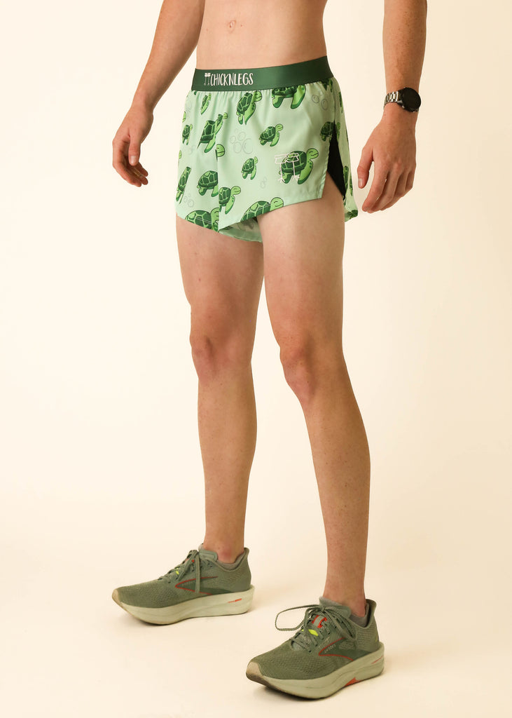 Model wearing Chicknlegs men's 2 inch split running shorts wearing the sea turtles design facing left.
